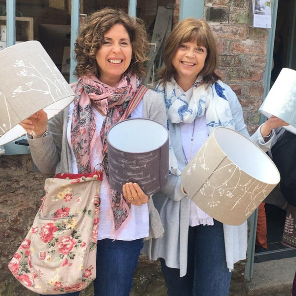 Lampshade Workshop-ladies holding a selection of lampshades in Natural, Slate Grey and Duck Egg Blue Linen from Helen Round.