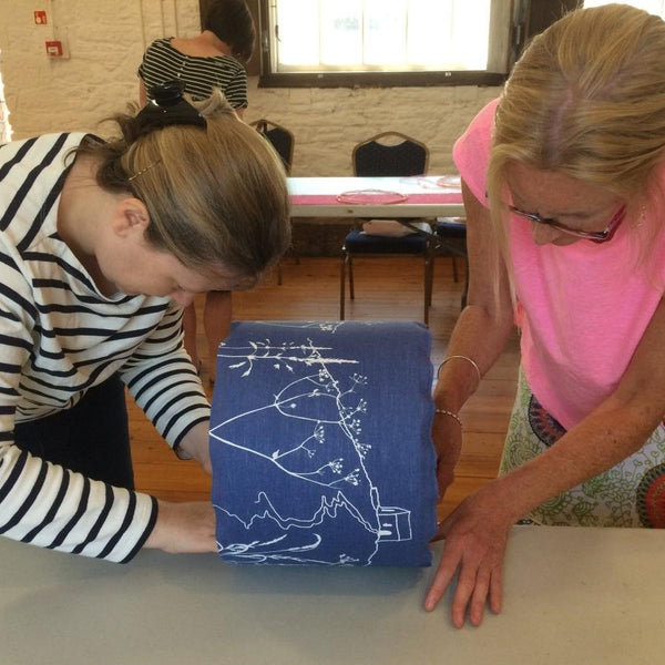 Two women making a lampshade with a Rame Head design on Indigo Blue Linen Panel for Lampshade Making Workshop with Helen Round